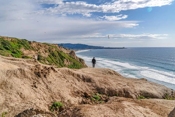 Homem na montanha rochosa que faz fronteira com a costa do oceano em San Diego Califórnia — Fotografia de Stock