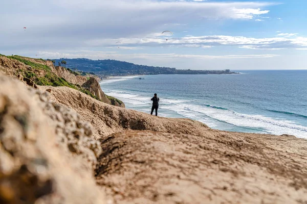 Homem com vista panorâmica do oceano com cais e paraquedas distantes em San Diego — Fotografia de Stock