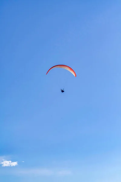 Paracadutista con paracadute rosso che vola contro il cielo blu a San Diego California — Foto Stock