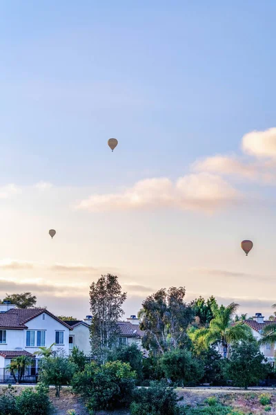 Balões de ar quente contra céu azul nublado sobre casas em San Diego Califórnia — Fotografia de Stock