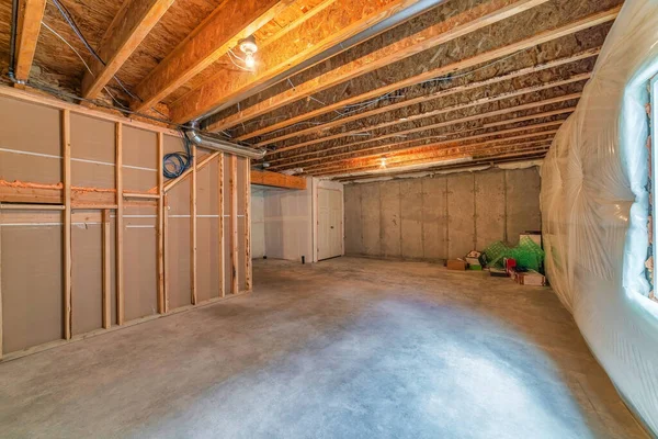 Wnętrze pomieszczenia w budowie z odsłoniętymi drewnianymi ramami i plastikiem na ścianie — Zdjęcie stockowe