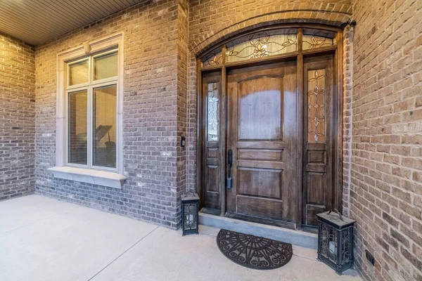 Hermosa fachada de casa con puerta delantera y ventana contra pared de ladrillo de piedra — Foto de Stock