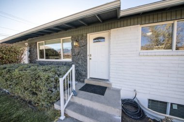 Taş, tuğla ve pencereli bir evin girişi.