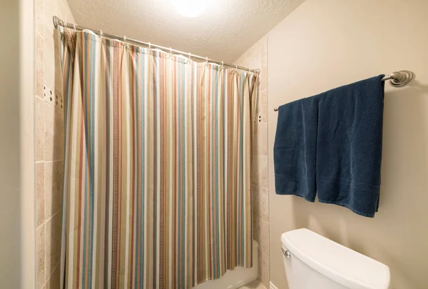Cortina de chuveiro fechada colorida em um banheiro sem janelas — Fotografia de Stock