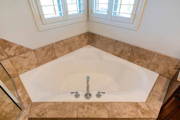 Close up top view of a corner bathtub in a bathroom with ceramic tile surround — Stock Photo, Image