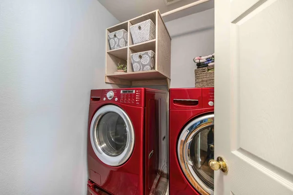 Small laundry room interior with red laundry machines — Stock Photo, Image