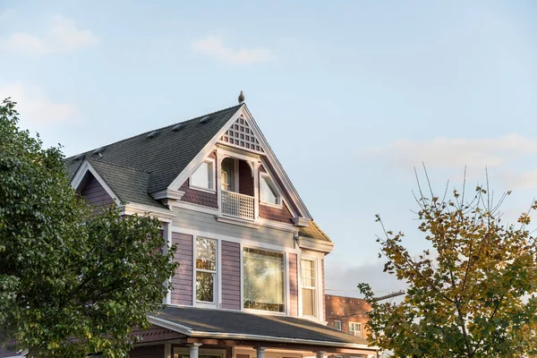 Onderdeel van een twee verdiepingen tellend traditioneel huisje met een zolderbalkon en een vogel op het dak — Stockfoto