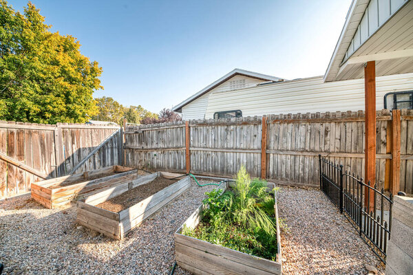Backyard with raised bed garden and wooden fence and gate