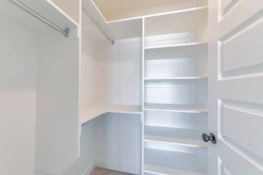 Dolabın içinde boş raflar ve açık kapıdan görünen çubuklarla yürüyün.