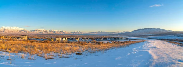 Obrovské sněhové pole s velkými domy v Saratoga Springs, Utah s výhledem na Wasatch Mountains — Stock fotografie