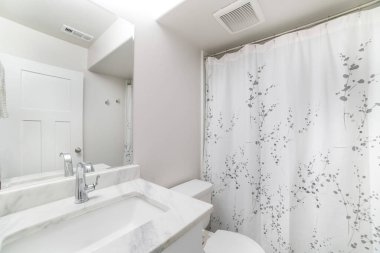 Beyaz lavabo mermer kapaklı ve aynalı bir banyonun içi.