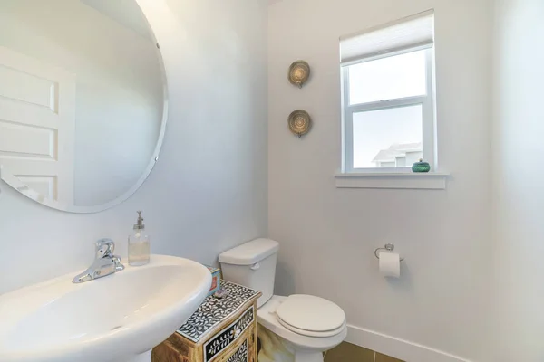 Wnętrze białej łazienki z oknami, lustrem, umywalką i szafką — Zdjęcie stockowe