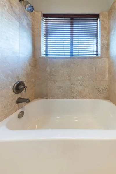 Kleine ruimte badkamer met keramische bad en een muur gemonteerde douchekop en kraan — Stockfoto