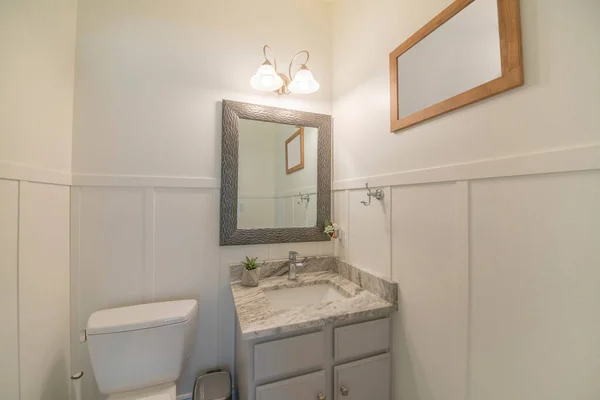 Интерьер белой окрашенной ванной комнаты с раковиной и зеркалом — стоковое фото