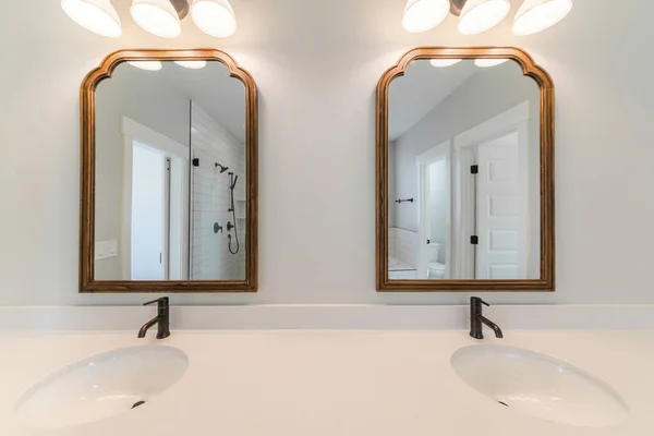 Foto recortada da vaidade com duas pias, duas torneiras simples e dois espelhos com molduras — Fotografia de Stock
