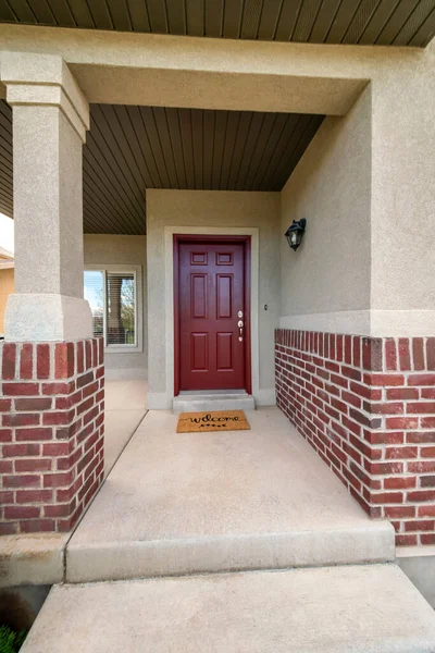 Porta da frente vermelha varanda exterior com tijolos e capacho bem-vindo — Fotografia de Stock