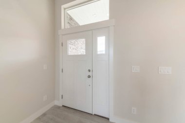 Yan paneli ve üst transom penceresi olan beyaz ahşap bir ön kapı.