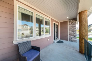 Pencereleri, kapısı ve taş duvarları olan bir evin önünde.