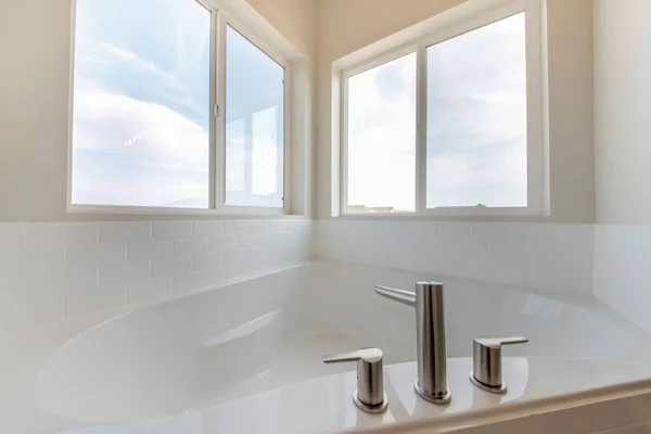 Wanna narożna w łazience z rozległym kranikiem przy oknach — Zdjęcie stockowe
