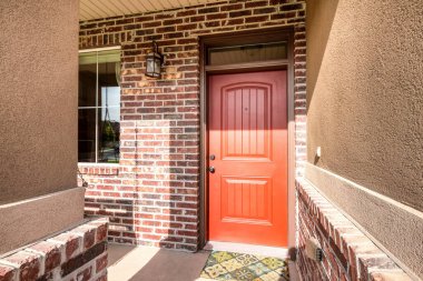 Ön kapı dış tarafı kırmızı tuğlalı duvarlar ve pencereli.