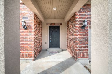 Ön kapı girişi, kırmızı tuğla duvarların ortasında.