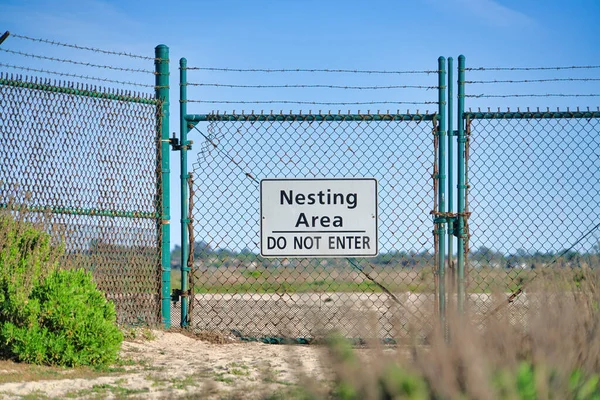 Do Not Enter sign on green fence at Bolsa Chica Ecological Reserve nesting area