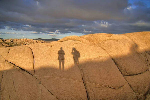 Stín dvou osob na skalní formaci v slunném národním parku Joshua Tree — Stock fotografie