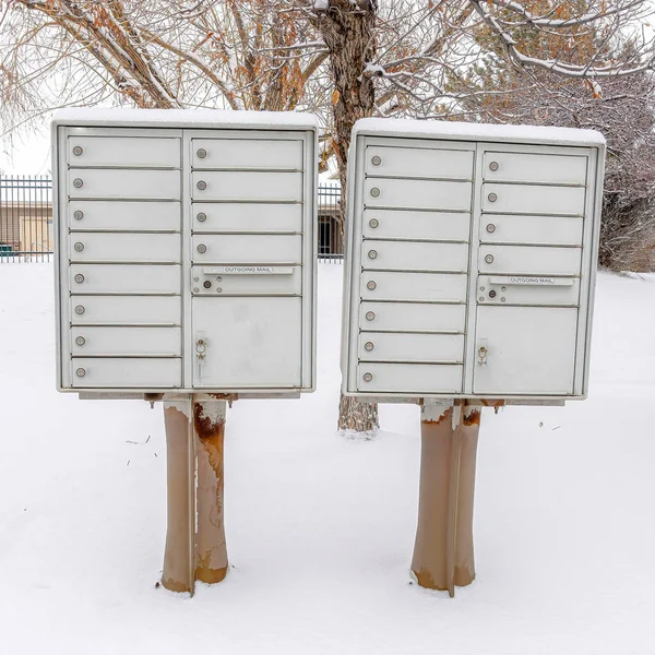 冬の住宅街の屋根付きの道端に雪の広場クラスタメールボックス — ストック写真