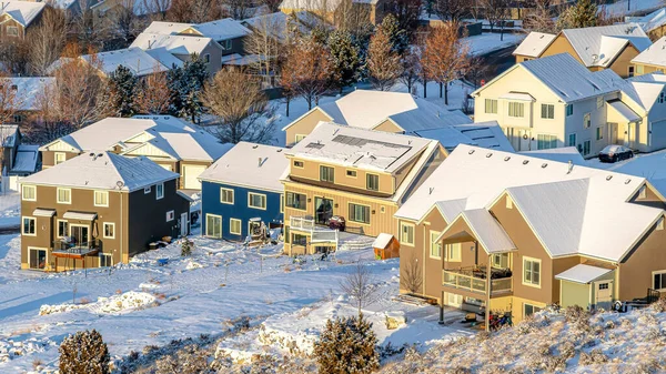 Pano Homes with snowy roofs against a white landscape of frost on a sunny day