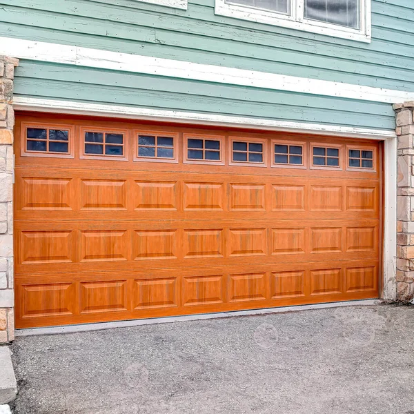 Square Wide brown door with glass panes of a two car garage of home with green wall — Foto de Stock