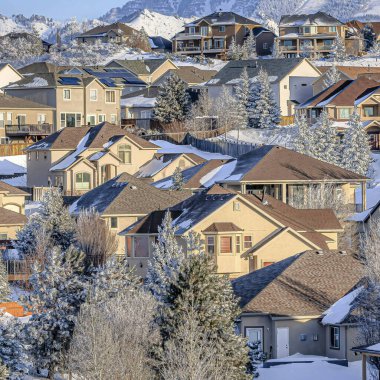 Kışın Utah Meydanı 'nda karlı dağlara ve bulutlu mavi gökyüzüne karşı evler