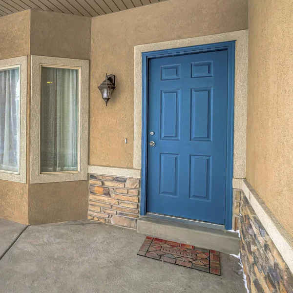 Plaza Bay ventana y puerta frontal de madera azul en la fachada del hogar con porche — Foto de Stock