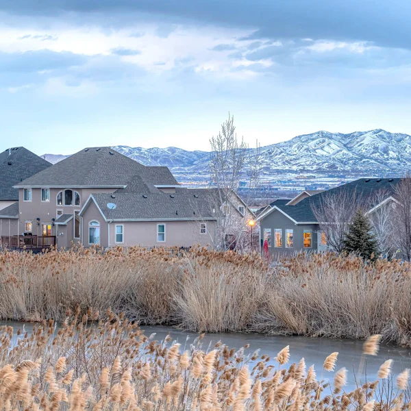 Casas cuadradas con vista al estanque y a la montaña Wasatch en un entorno invernal nevado — Foto de Stock