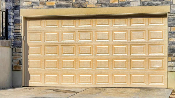Pano Large porte de garage lambrissée de la maison avec mur de briques de pierre sur un quartier ensoleillé — Photo
