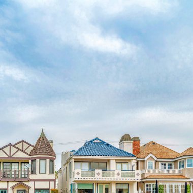 Long Beach California 'da bulutlu gökyüzüne karşı ön balkonları olan kare şeklinde evler.