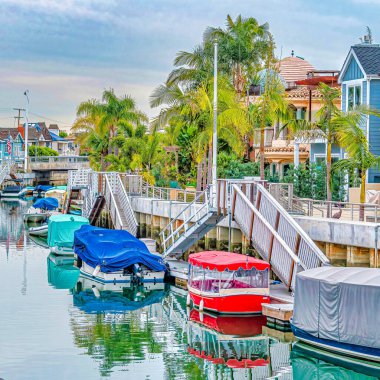 Güzel Long Beach CA mahallesinde merdivenleri ve tekne rıhtımı olan kare kanal.