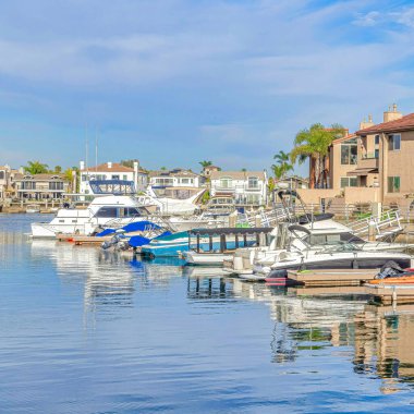 Kare botlar limana Huntington Sahili California 'daki rıhtım evleriyle kenetlendi.