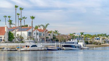 Pano Denizi ve tekneleri ve rıhtımı olan evler bulutlara ve mavi gökyüzüne karşı