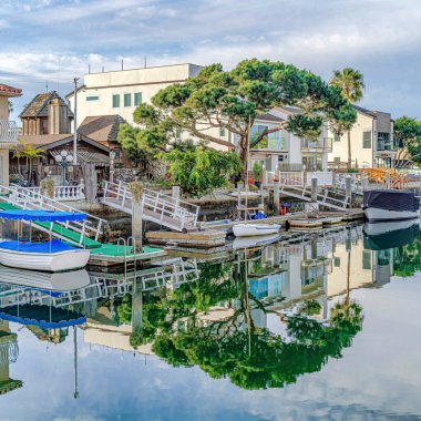 Huntington Sahili 'ndeki Kare Su Ağaçların ve gökyüzünün yansımasıyla Kaliforniya Limanı