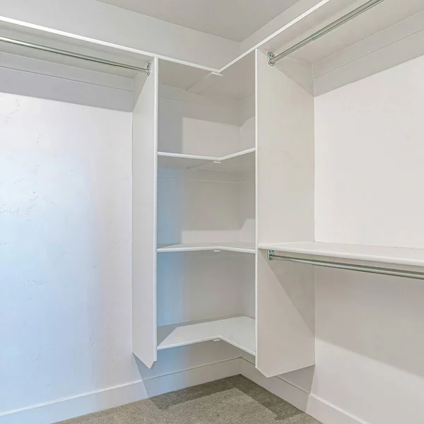 Plaza Interior de un walk in closet con estantes y varilla de ropa montada en pared blanca — Foto de Stock