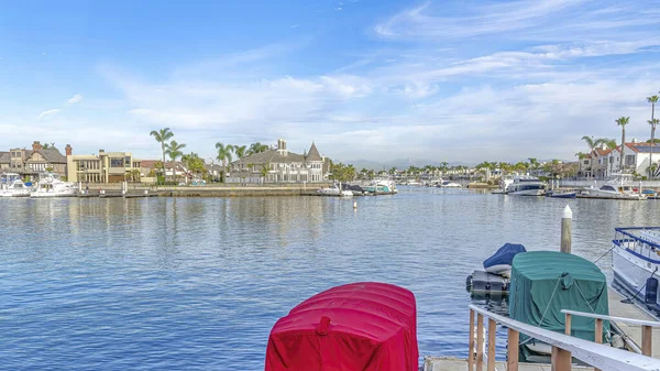 Pano Serene zee weerspiegelt blauwe lucht in het schilderachtige Huntington Beach met huizen aan het water — Stockfoto