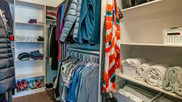 Camisas y abrigos de Pano en varillas en el interior walk in closet de casa con suelo de alfombra marrón — Foto de Stock