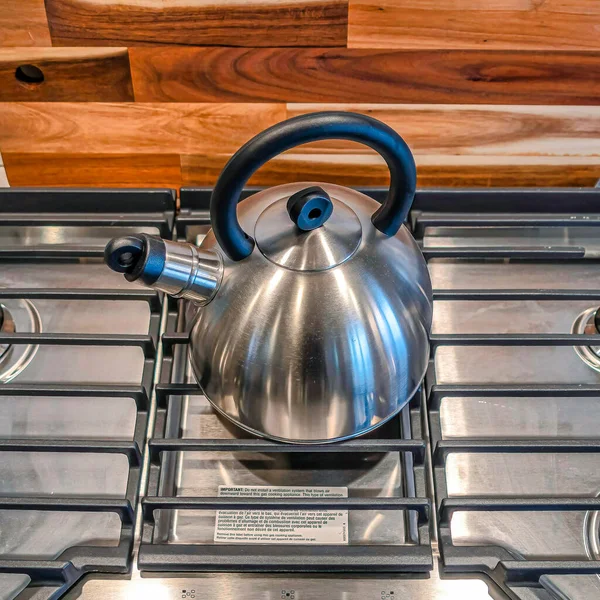 Square Kettle over burners and grate of a cooktop built into the kitchen countertop — Stock Photo, Image