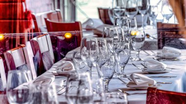 Şarap kadehleri ve cam pencereden görünen sofra takımı ile Pano yemek masası