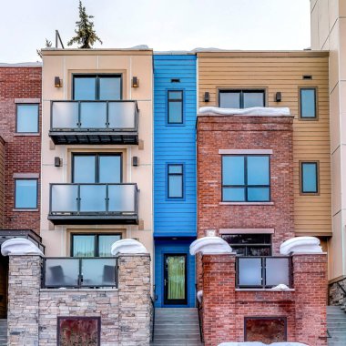 Kışın karlı, düz çatılı ve girişi merdivenli bir apartman dairesi.