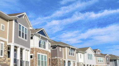 Güzel evlerin Pano Row 'u bulutlu mavi gökyüzüne karşı huzurlu bir muhitte.