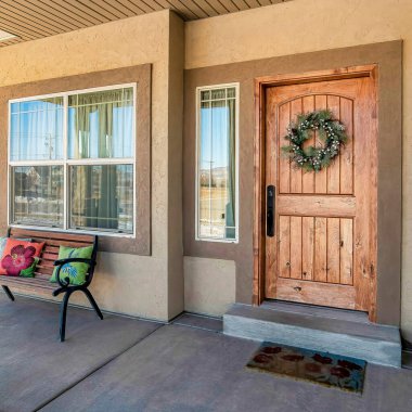 Tavan lambaları ve bankta beton zemin bulunan açık veranda.