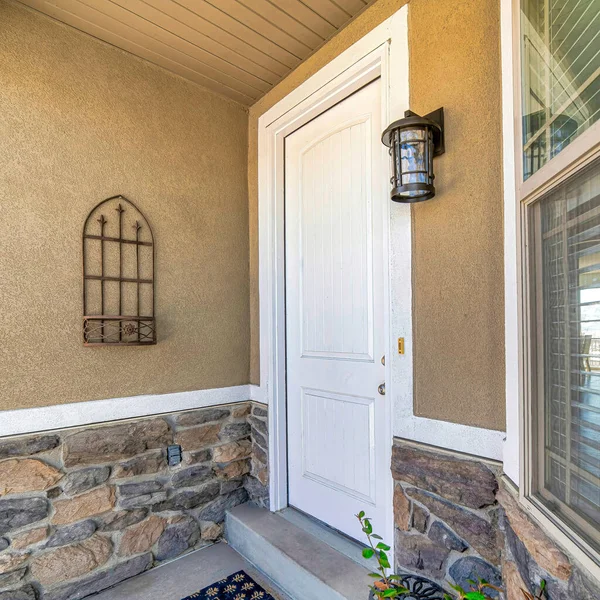 Квадрат Белая дверь и окно с жалюзи на домашнем фасаде с бетонной и каменной стеной — стоковое фото