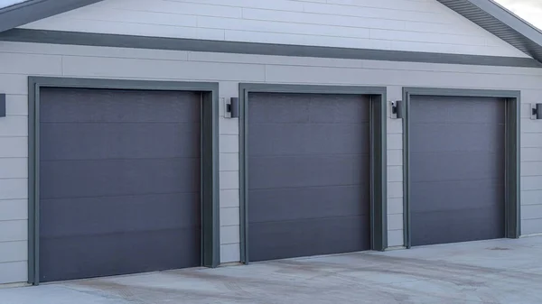 Pano Home extérieur avec trois portes grises à l'entrée du garage résidentiel — Photo