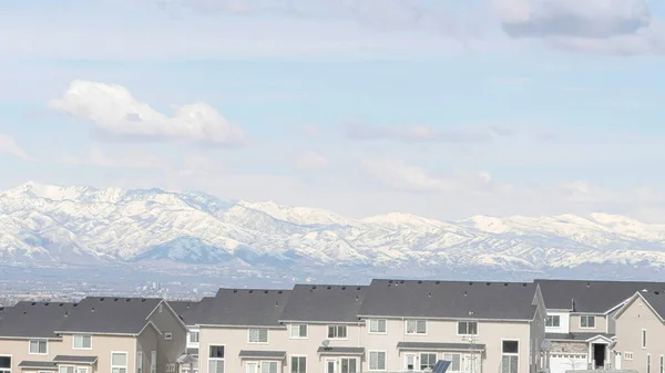 Pano-Häuser gegen schneebedeckten Berg und malerische Wolkenkratzer in einer Nachbarschaftslandschaft — Stockfoto